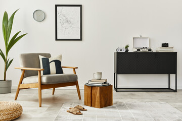 Modern retro concept of home interior with design grey armchair, coffee table, plants, mock up poster map, carpet and personal accessoreis. Stylish home decor of living room.