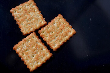 three square cookies on a dark background