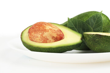 Group of fresh avocados. Slices on a plate isolated on a white background. Side view. closeup