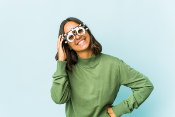 Young oculist latin woman over isolated background