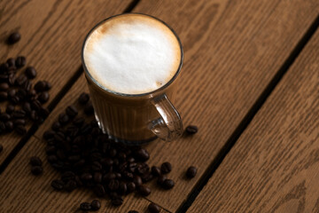 Hot coffee latte and beans on the wooden floor