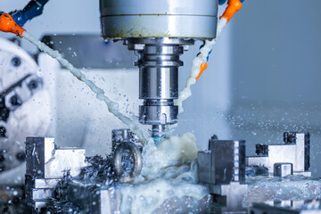 vertical cnc steel milling process with external water coolant streams, splashes and a lot of metal chips, high contrast