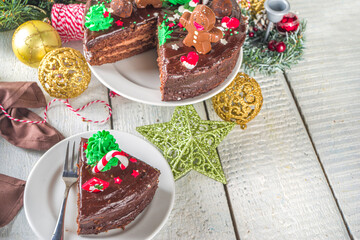 Christmas Chocolate Cake. Homemade Gingerbread Chocolate Cake with Sugar and Chocolate Decor in form of Xmas traditional Symbols - candy cane, gingerbread man, xmas tree,