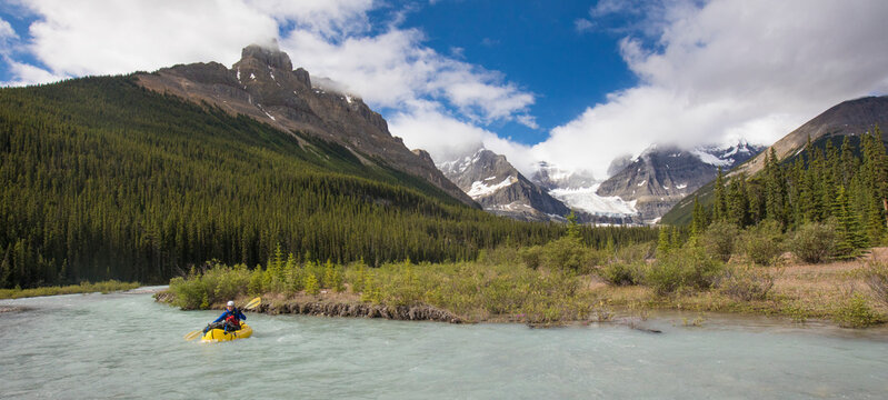 Panoramic view of explorer packrafting in Banff National Park. - Powered by Adobe