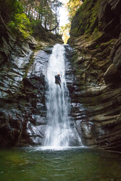 Brave man rappelling down waterfall in Cypress Canyon.