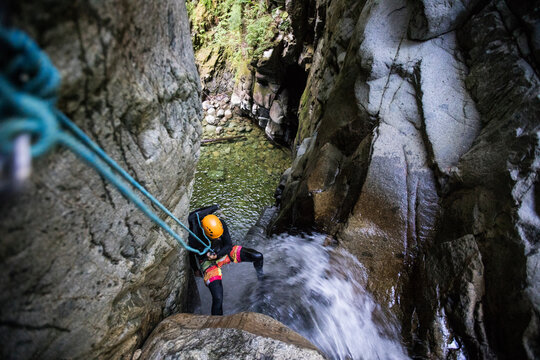 High angle view of man rappelling down waterfall in Cypress Canyon.