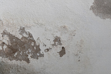 Old white concrete wall background with peeled off color surface.Caused by moisture.