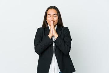 Young asian bussines woman isolated on white background holding hands in pray near mouth, feels confident.