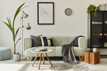 Stylish loft interior with green sofa, design pouf, mock up poster map, furniture, carpet, plants, decoration and elegant accessories. Modern home decor. Template.