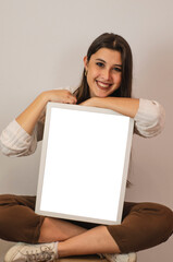 mujer con cuadros para fotografías de diferentes tamaños con fondos blancos 