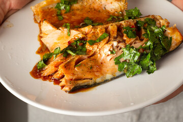 baked salmon in male hands close up
