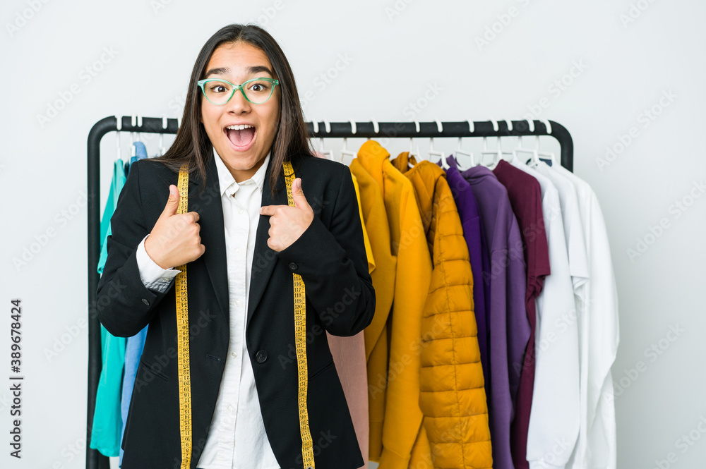 Wall mural Young asian designer woman isolated on white background surprised pointing with finger, smiling broadly.