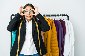 Young asian designer woman isolated on white background keeping eyes opened to find a success opportunity.