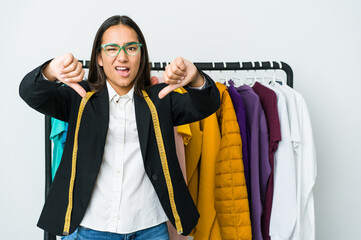 Young asian designer woman isolated on white background showing thumb down and expressing dislike.