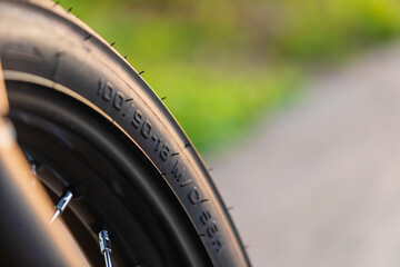 Number code on the front motorcycle rubber wheel. Outdoor shooting on the road with copy space