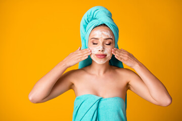 Photo of young attractive beautiful woman girl female wash face with foam isolated on yellow color...