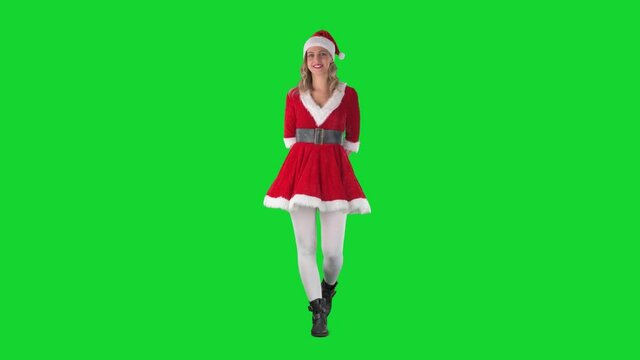 Happy Santa girl holding hands behind back giving Christmas present with open hands. Full body length on green screen. 