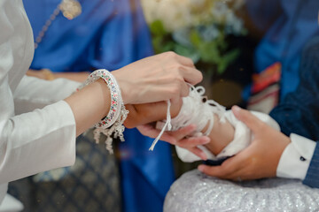The image of tie the wrist in the Thai marriage tradition