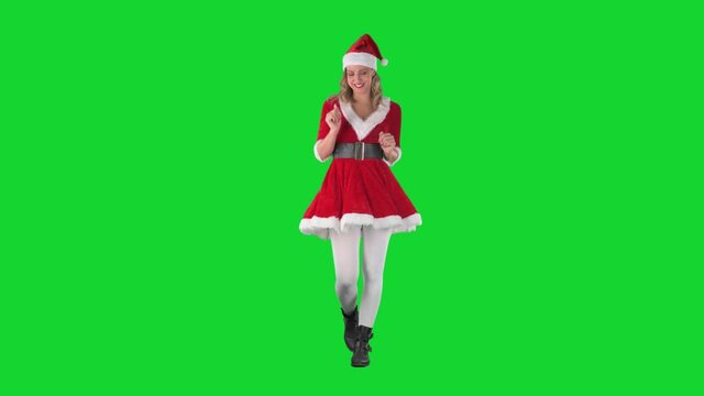 Playful happy Santa Claus girl walking and dancing to music. Full body length on green screen. 