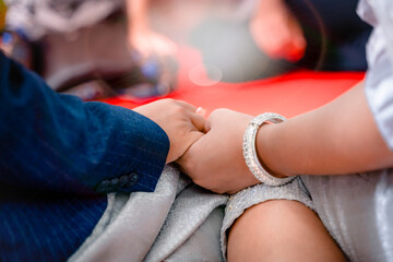 Fototapeta premium A couple holding hands in a happy wedding ceremony