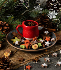 Hot tea on a red cup and Christmas cookies with a star and snowman shape