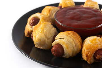 Pigs in blankets. Mini sausages wrapped in puff pastry with ketchup sauce isolated on white background