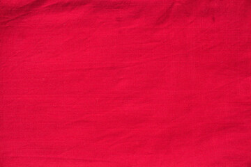  The texture of red linen dense fabric of bright red color close-up. Textured abstract red background, top view