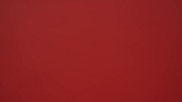 Confused Santa faints on a red wall background. Santa turned his head at Christmas on a red background. Santa is sick.