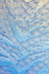 Frost forms in patterns on window glass on a cold winter morning