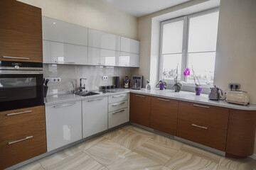 View of luxury modern fitted kitchen with stainless steel appliances