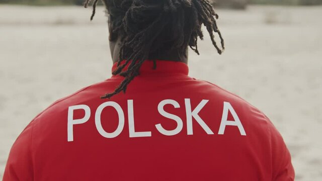 Back view of african american black man in red shirt. Poland writen on the back