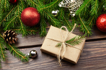 Christmas gift box with fir tree branches on wooden background