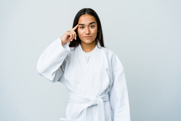 Young asian woman doing karate isolated on white background pointing temple with finger, thinking,...