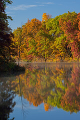 Autumn landscape of Eagle Lake with mirrored reflections in calm water, Fort Custer State Park, Michigan, USA