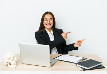 Young traumatologist asian woman isolated on white background excited pointing with forefingers away.