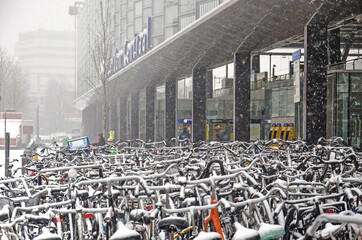 Rotterdam, The Netherlands, January 22, 2019: large number of bicycles parked near the rear entrance to the central station during a snow storm