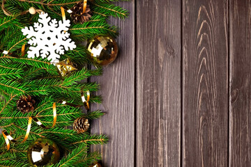 Fir tree branches with christmas decorations on wooden background
