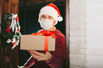 courier delivers a gift on Christmas Eve in a mask from the coronavirus