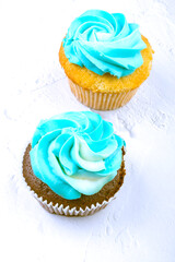 two tasty Cupcakes or muffin with blue cheese cream frosting on white background