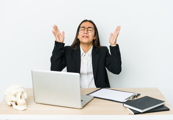 Young traumatologist asian woman isolated on white background screaming to the sky, looking up, frustrated.