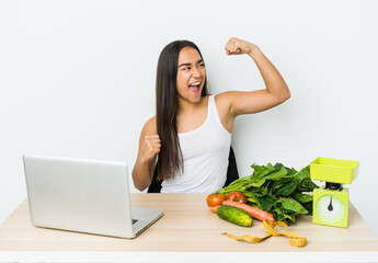 Young dietician asian woman isolated on white background raising fist after a victory, winner concept.