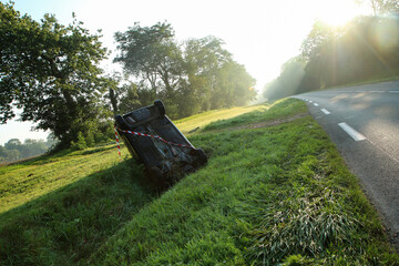 Abandoned car in the ditch after the traffic accident. Lying on the roof.