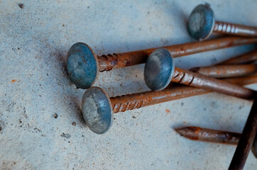 long metal nails on a concrete surface
