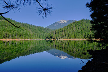 Looking across calm Trinity Lake to snowcapped Trinity Alps, CA - Powered by Adobe