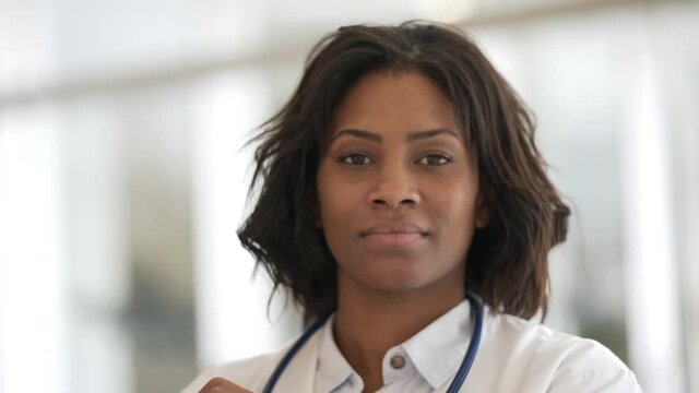 Smiling woman doctor standing in hospital hallway