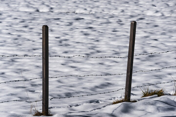 Stacheldrahtzaun im verschneiten Feld