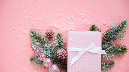 Christmas flat lay pink paper background with gift box, fir tree branches and decor