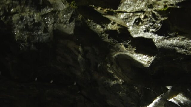 Walk through a dark cave. Speleology and geology theme 4k video.