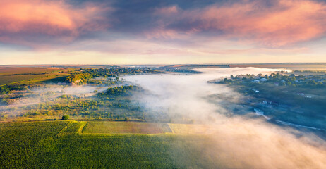 View from flying drone. Foggy morning scene of Ukrainian countryside. Exciting summer sunrise on outskirts of Ternopil town, Ukraine, Europe. Traveling concept background..