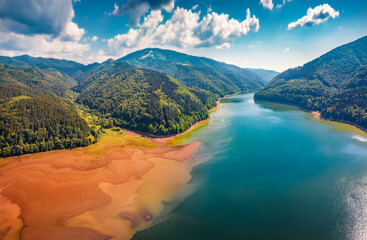 Red sand shore onTereblia-Ristke Reservoir. View from flying drone. Colorful morning scene of...